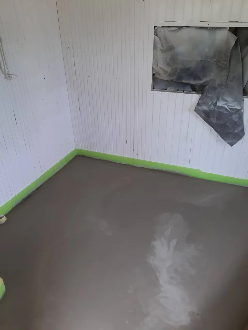 Izravnana tla po odstranitvi starega itisona, robovi zaščiteni z zelenim lepilnim trakom